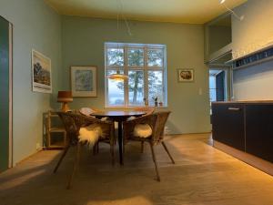 a dining room with a table and chairs and a window at Agerdal - dejligt hus midt i mark og have in Nykøbing Mors