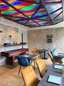 a restaurant with a piano and tables and chairs at Logis Hôtels - Hôtel et Restaurant Le Lion d'Or in Gramat