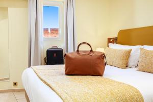 a bag of luggage sitting on a bed in a hotel room at Résidence Aston la Scala in Nice +134 photos