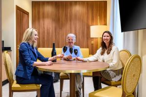 three women sitting around a table in a room at Résidence Aston la Scala in Nice