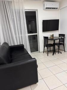 a living room with a black couch and a table at Mar doce lar in São Luís