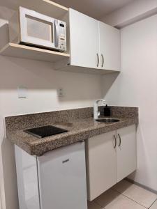 a kitchen with a sink and a microwave at Mar doce lar in São Luís
