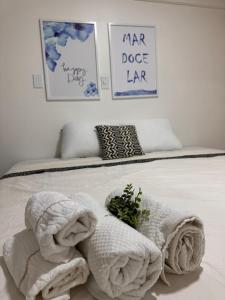 a bed with towels on top of it with three pictures at Mar doce lar in São Luís