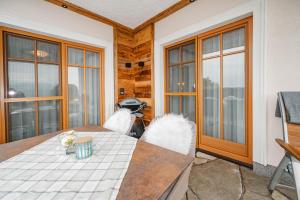a dining room with a table and some windows at Landhaus Armstorfer in Puch bei Hallein