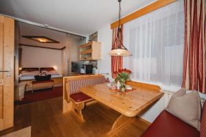 a living room with a wooden table and a bedroom at Landhaus Armstorfer in Puch bei Hallein