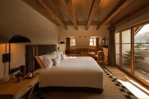 a bedroom with a large white bed and a table at Castel Badia - The Leading Hotels of the World in San Lorenzo di Sebato +98 photos