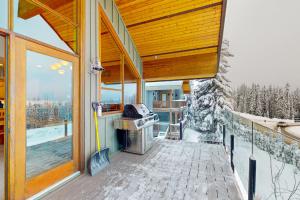 a balcony of a house with a grill at Coyote Creek Chalet in Big White