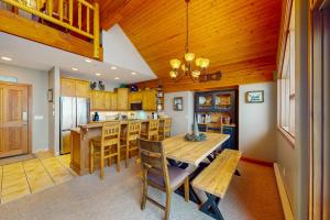 a kitchen with a table and chairs and a refrigerator at Coyote Creek Chalet in Big White