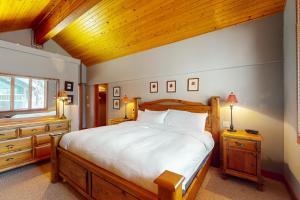 a bedroom with a large bed and a wooden ceiling at Coyote Creek Chalet in Big White