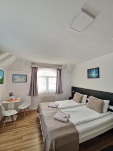 a bedroom with a large bed and a table at Erdős Panzió in Ditrău