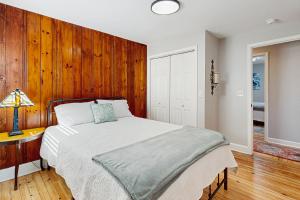 a bedroom with a bed and a wooden wall at Private Patio & Pond: Serene Black Mountain Escape in Black Mountain