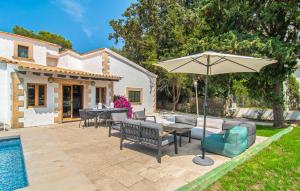 a patio with a table and an umbrella next to a pool at El Tulipan Blanco in Alcudia