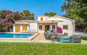 a villa with a swimming pool and a house at El Tulipan Blanco in Alcudia