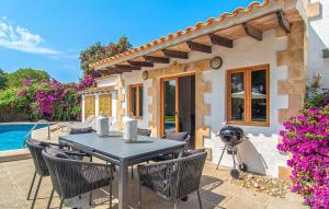 a patio with a table and chairs in front of a house at El Tulipan Blanco in Alcudia