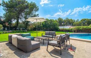a patio with furniture and an umbrella next to a pool at El Tulipan Blanco in Alcudia
