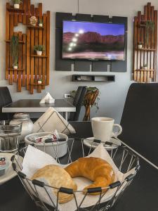 a table with a basket of bread and a tv at Petit Hotel Las Marias in La Rioja