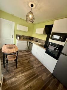 a kitchen with a wooden table and a tableasteryasteryasteryasteryasteryasteryastery at Have a Cosy, Élégance in Grand-Fort-Philippe