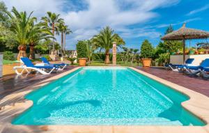 a swimming pool in a villa with palm trees at Ca Na Pepa in Muro