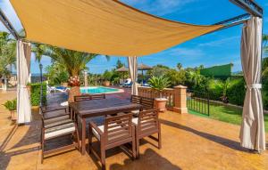 a patio with a table and chairs and a pool at Ca Na Pepa in Muro