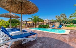 a villa with a swimming pool with chairs and an umbrella at Ca Na Pepa in Muro
