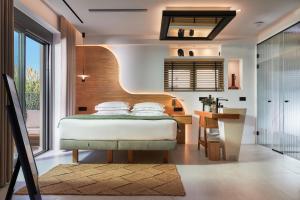 a bedroom with a bed and a desk and a kitchen at Diastar Luxury Suites NEW in Heraklio