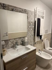 a bathroom with a sink and a toilet and a mirror at A casa di Lena in Genzano di Roma