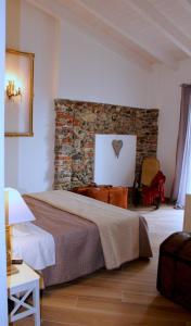 a bedroom with a large bed and a stone wall at La Piccola Corte di Malpensa in Vizzola Ticino