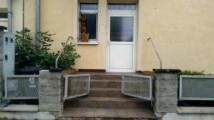 a house with a white door and stairs leading to it at apartman-Rača in Bratislava