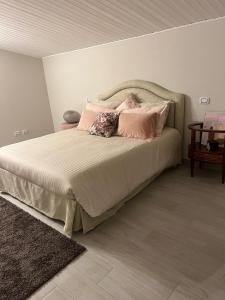 a bed with pink pillows in a bedroom at A casa di Lena in Genzano di Roma