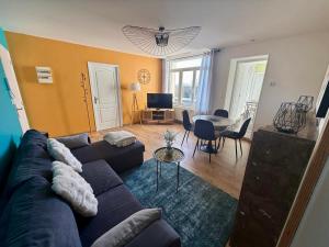 a living room with a couch and a table at Have a Cosy, Élégance in Grand-Fort-Philippe