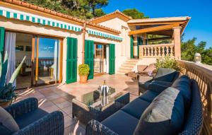a patio with blue chairs and a table on a house at Ventimar in Canyamel +39 photos