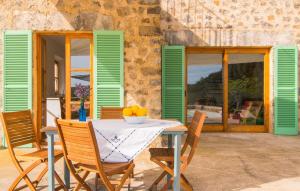 a table and chairs on a patio with green shutters at Son Frare in Artá