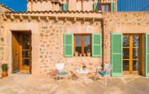 a patio with green shutters and a table and chairs at Son Frare in Artá