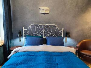 a bedroom with a blue bed with a mask on the wall at Red Doors Apartament 23 Free Parking in Riga