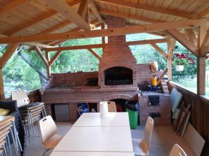 an outdoor kitchen with a brick fireplace in a house at Lotru Relax Chalet in Malaia