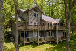 a large house with a deck in the woods at Meadow Lake View by Railey Vacations in Swanton