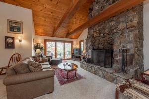 a living room with a large stone fireplace at Meadow Lake View by Railey Vacations in Swanton