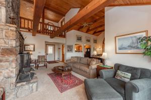 a living room with couches and a stone fireplace at Meadow Lake View by Railey Vacations in Swanton