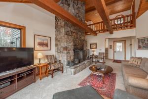 a living room with a large stone fireplace at Meadow Lake View by Railey Vacations in Swanton