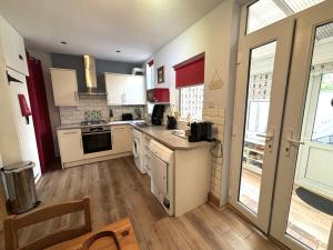 a kitchen with white cabinets and a counter top at Downs Gate Cottage in Eastbourne