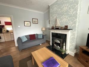 a living room with a couch and a fireplace at Downs Gate Cottage in Eastbourne