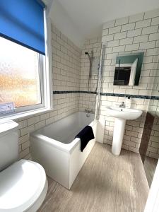 a bathroom with a sink and a tub and a toilet at Downs Gate Cottage in Eastbourne +22 photos