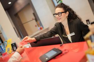 a woman sitting at a table with a cell phone at Bhotel in Lagonegro