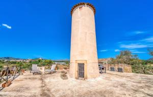 a tall brick tower sitting on top of a yard at Moli Den Guixo in Artá