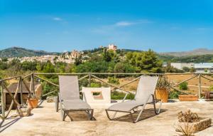 two white chairs sitting on a patio with a view at Moli Den Guixo in Artá