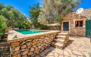 a stone retaining wall around a swimming pool in a house at Moli Den Guixo in Artá