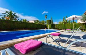 a swimming pool with two lounge chairs and a purple towel at Gatoses in Sa Coma