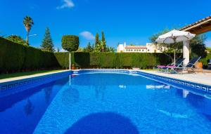 a swimming pool in a yard with chairs and an umbrella at Gatoses in Sa Coma +44 photos