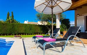 a group of chairs and an umbrella next to a pool at Gatoses in Sa Coma