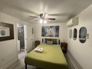 a bedroom with a green bed with a ceiling fan at Studio Apartment Antonine in New Orleans